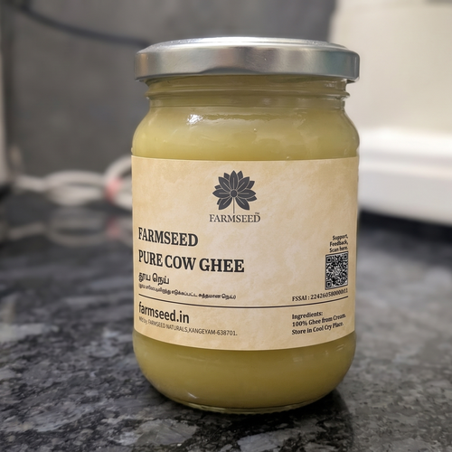 A jar of Farmseed Pure Cow Ghee on a dark granite countertop, with a blurred kitchen background.